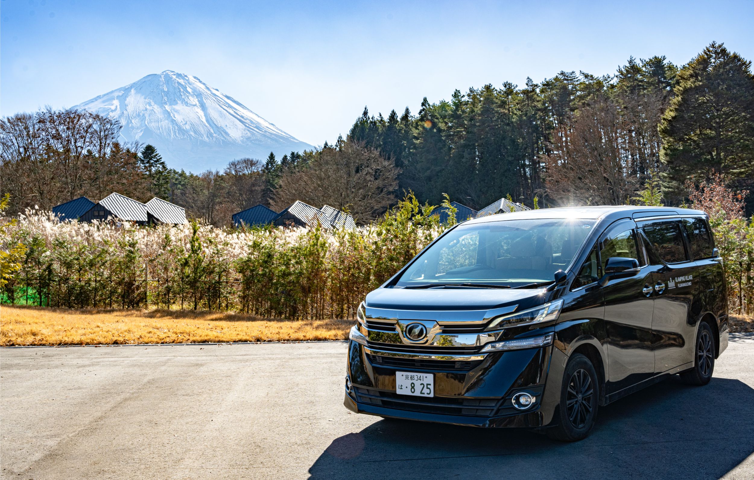 A shuttle vehicle from the property parked with Mt. Fuji behind it