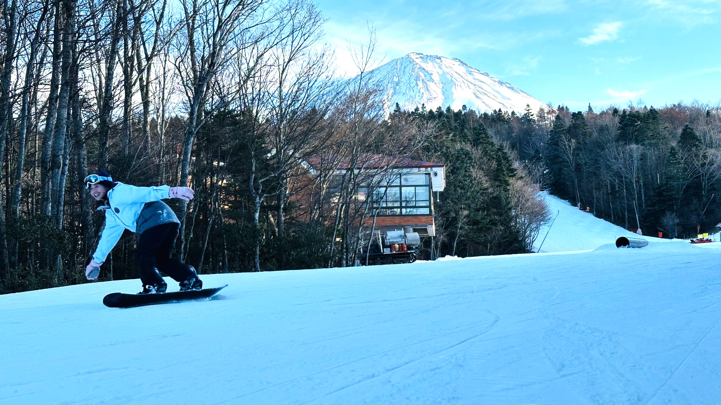 Skiing down a slope with Mt. Fuji behind