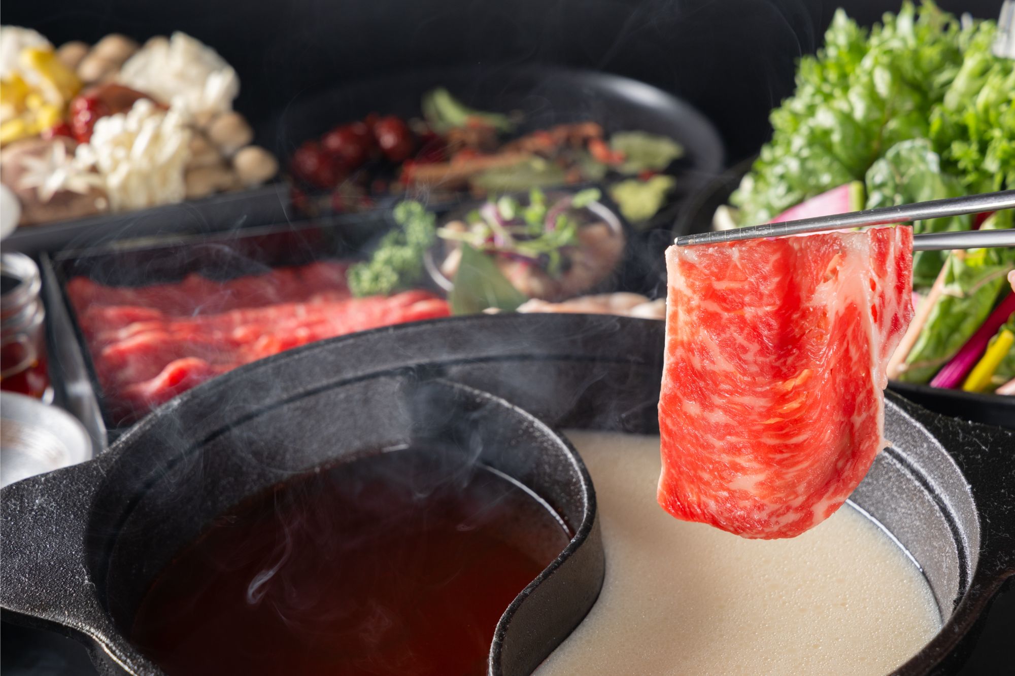 Beef being cooked in a red hot pot broth